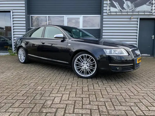 Zwarte Audi A6 voor het pand