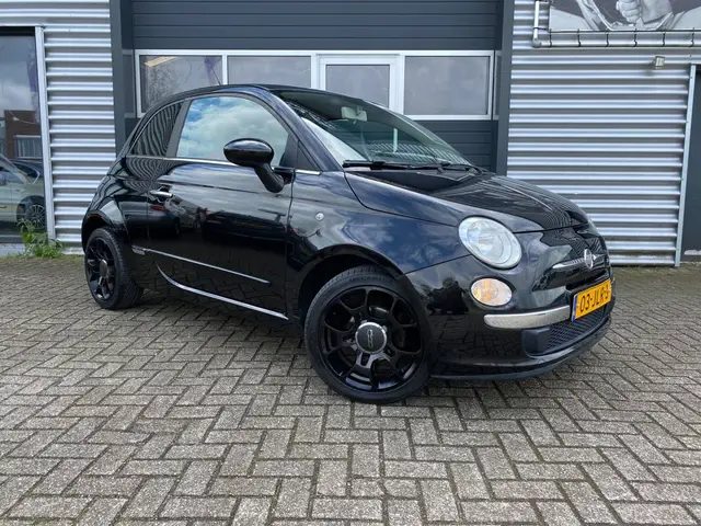Zwarte Fiat 500 voor het pand