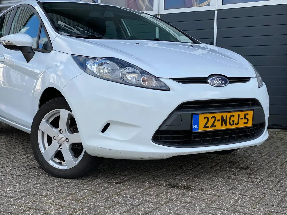 Witte Ford Fiesta voor het pand