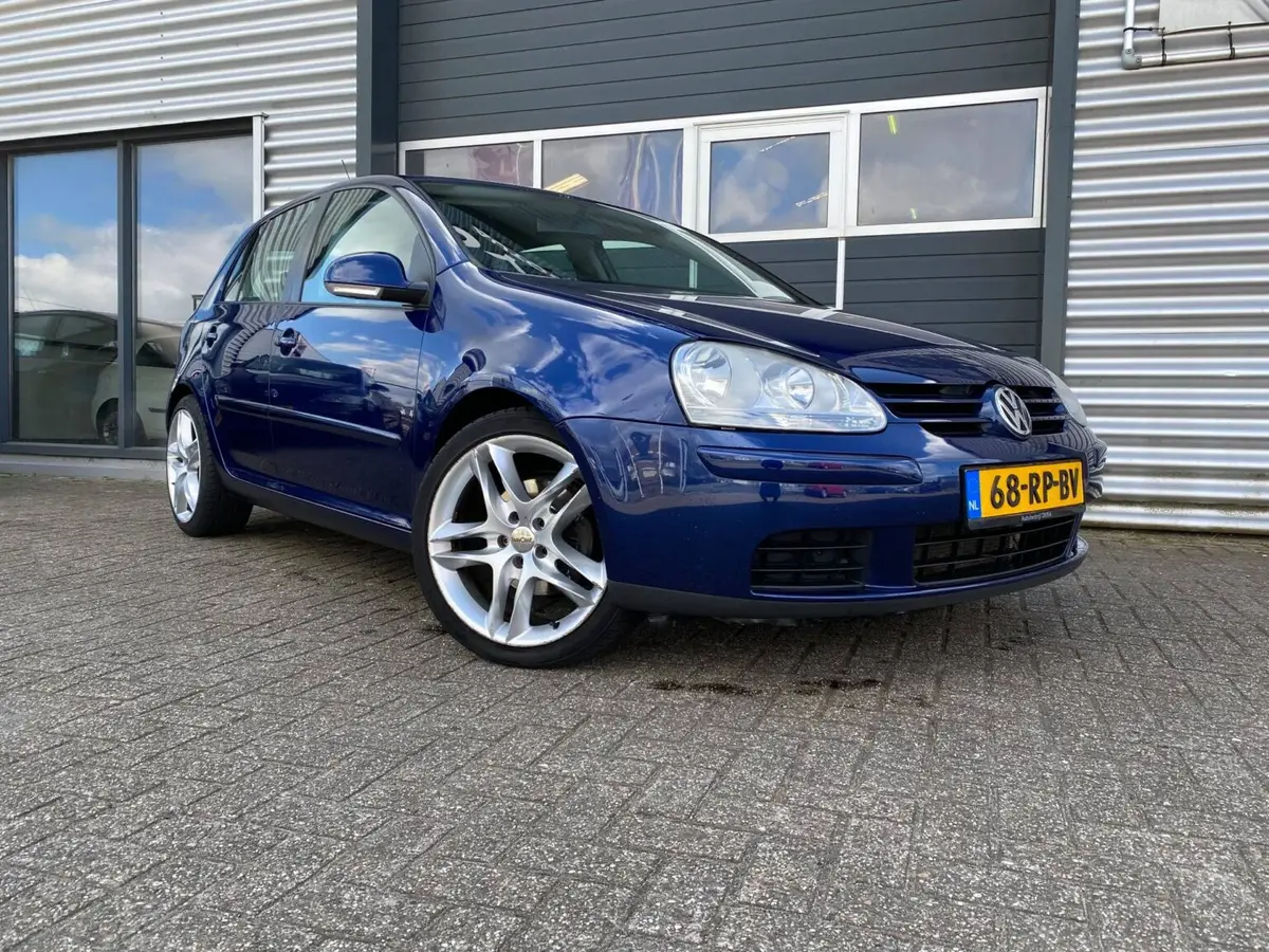 Blauwe Volkswagen Golf voor het pand